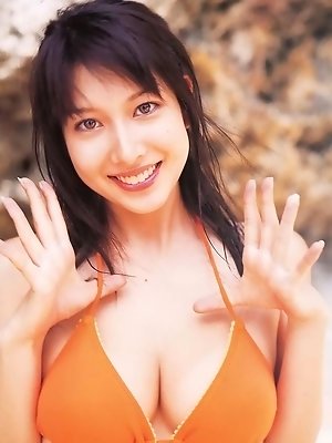 Busty asian beauty enjoying herself in a bikini at the beach